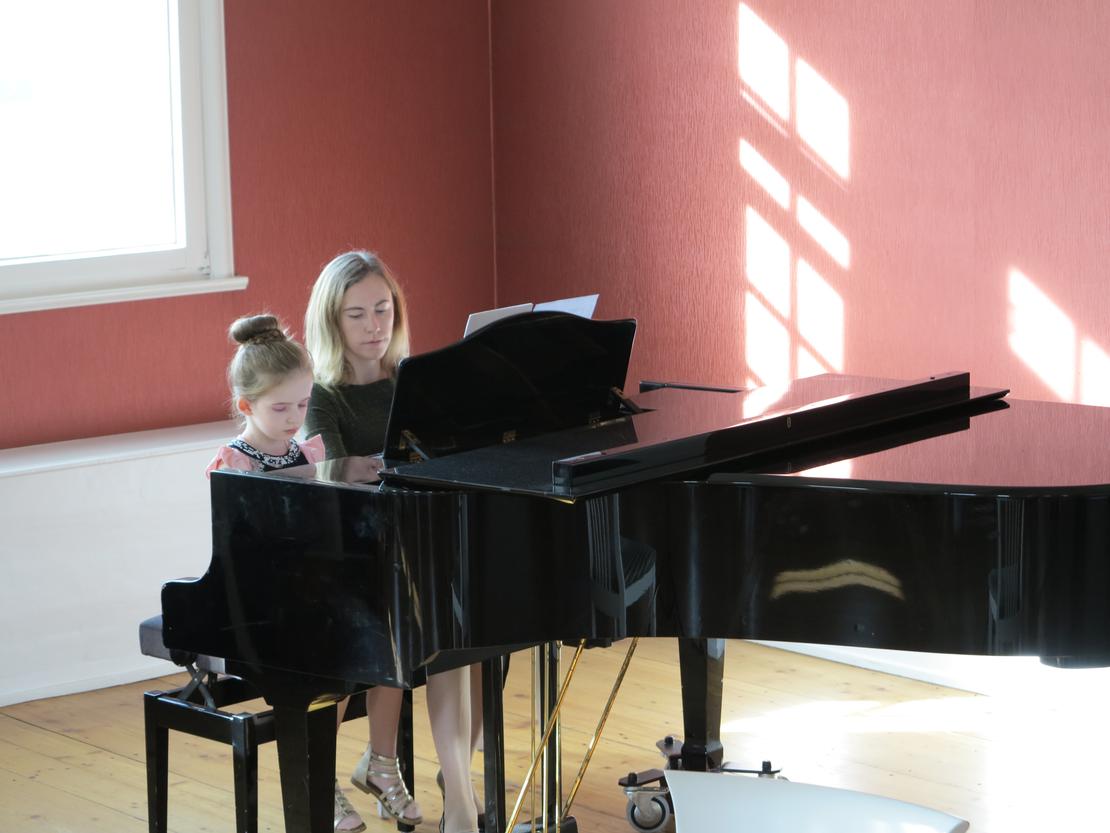 Gloria mit ihrer Lehrerin am Klavier