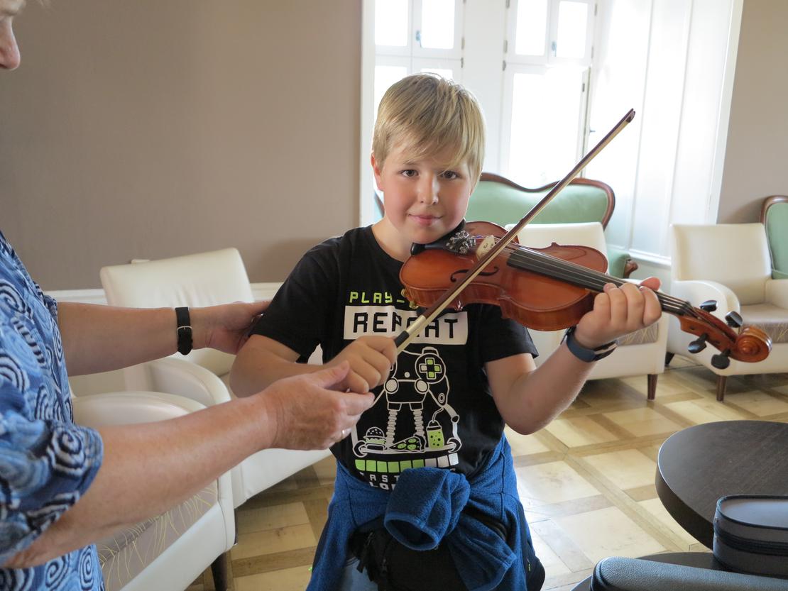 Kinder probieren Instrumente aus - Geige