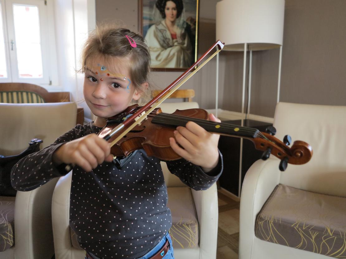 Kinder probieren Instrumente aus - Geige
